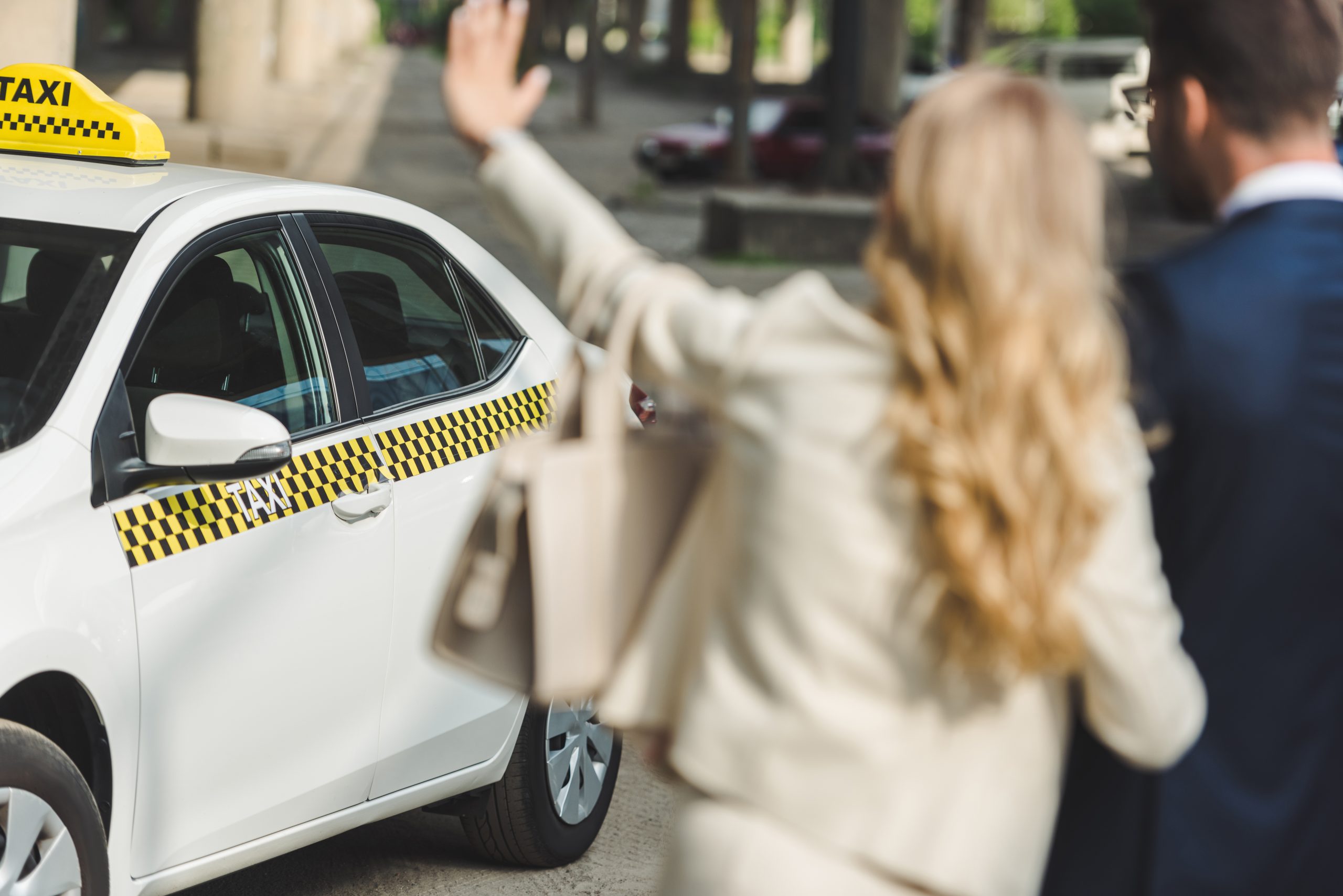 woman waving at a taxi